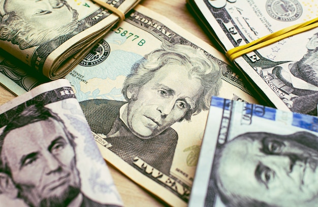 US Dollar bills on a wooden table in closeup photography