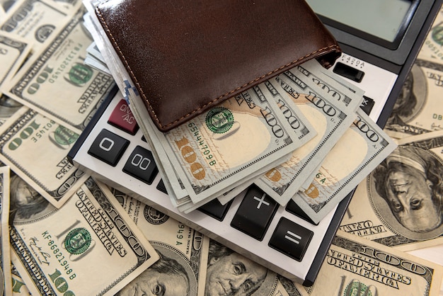 Us dollars bills in the wallet with calculator. Financial business concept.