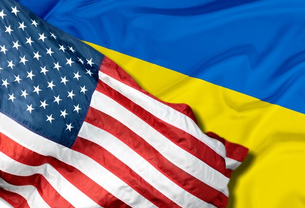 Photo us flag together with ukrainian flag in a single picture blending one into the other