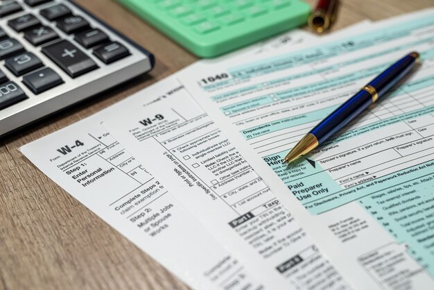 Us tax form 1040 w4 w9 with pen on desk Financial concept Tax time