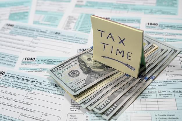 US tax forms 1040 with dollar bills and inscriptions spread out on a spacious table