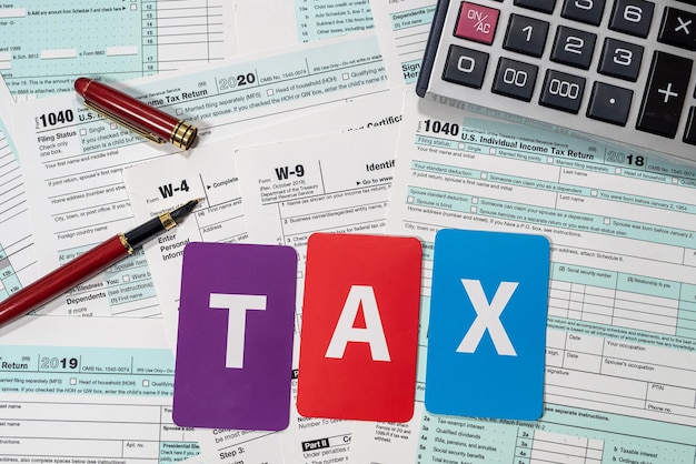 US tax forms 1040 with dollar bills and inscriptions spread out on a spacious table