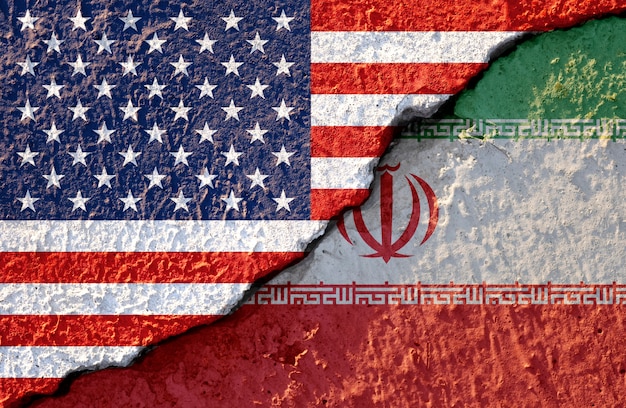 ひびの入った壁の損傷にアメリカ国旗とイラン国旗