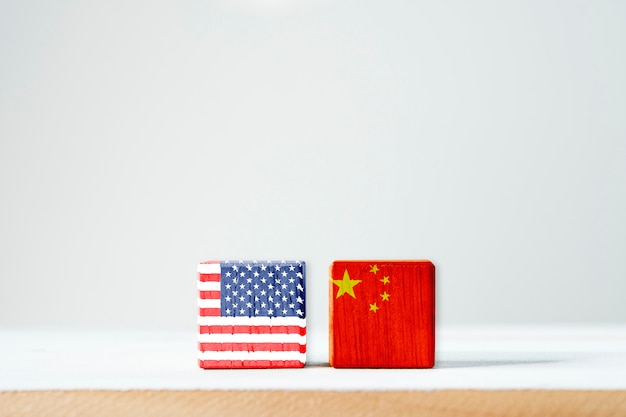 La bandiera di usa e la bandiera della cina stampano lo schermo su cubico di legno è simbolo della barriera fiscale di guerra commerciale di tariffa fra stati uniti d'america e la cina