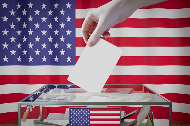 アメリカ国旗の手が選挙の概念を投票するボックスに投票カードを落とす