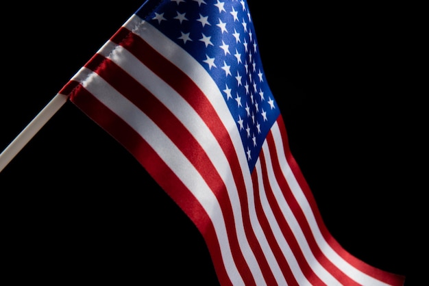 アメリカの国旗は、暗い背景分離に対して風に発展しています。