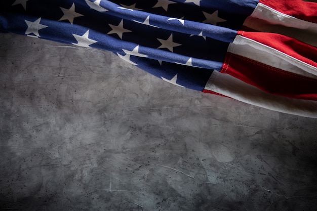 写真 セメントの背景の上に横たわる米国旗。アメリカの象徴。 7月4日またはアメリカ合衆国の記念日。テキストのコピースペース
