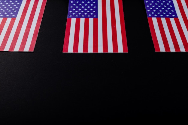 Foto bandiere statunitensi a stelle e strisce appiattite dallo spazio di copia su sfondo nero. patriottismo, simbolo e identità.