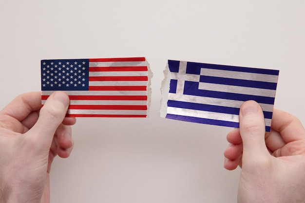 Usa and greece paper flags ripped apart political relationship concept