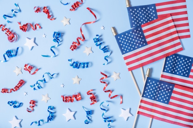 USA Independence day concept USA flags and Red and blue spirals and white stars top view flat lay on blue background