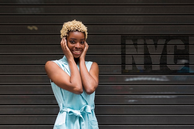 USA, New York, happy young blonde african-american woman, smiling, hand on head