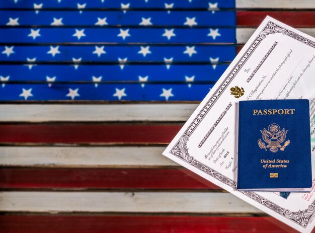 USA passport and naturalization certificate over US Flag