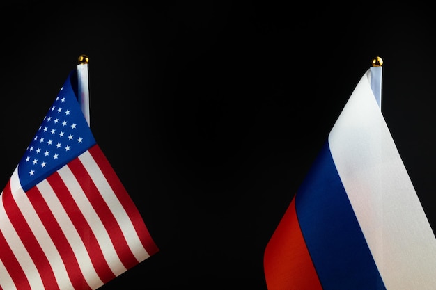 USA vs Russia flags on black background copy space photo Concept of world crisis cold war sanctions pressure