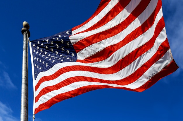 USA. Wind blown flag the United States of America over sky background.