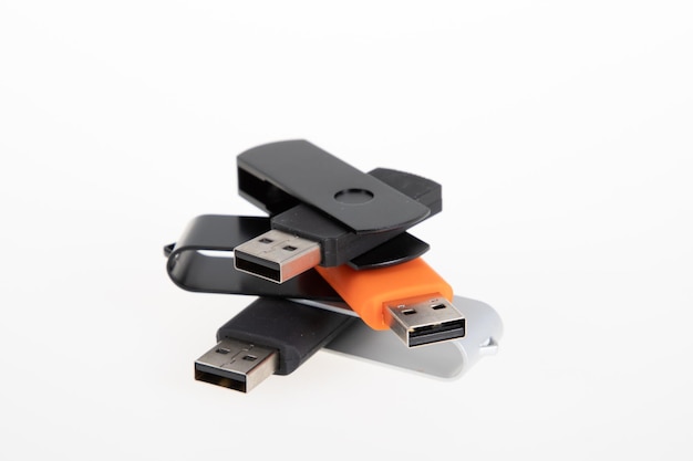 白い背景に配置されたピラミッドに積み上げられた USB フラッシュ ドライブの異なる USB キー