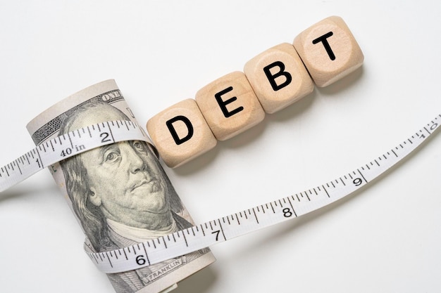 usd dollar banknote was wrapped by a tape measure for united states of america's public debt is high and the debt ceiling needs to be raised concept
