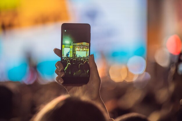 Use advanced mobile recording fun concerts and beautiful lighting Candid image of crowd at rock concert Close up of recording video with smartphone Enjoy the use of mobile photography