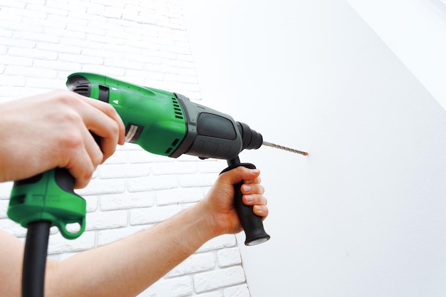 Use hammer drill to drill the wall