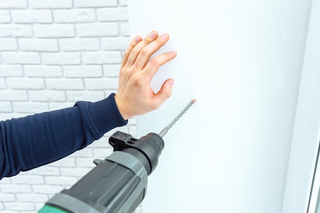 Use hammer drill to drill the wall