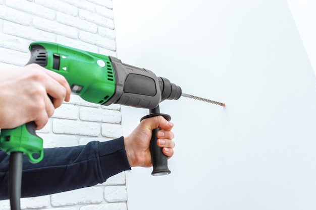 Use hammer drill to drill the wall