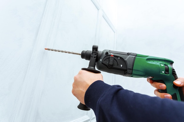 Use hammer drill to drill the wall