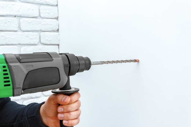 Photo use hammer drill to drill the wall