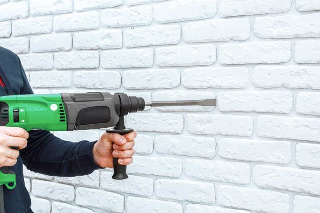 Use hammer drill to drill the wall