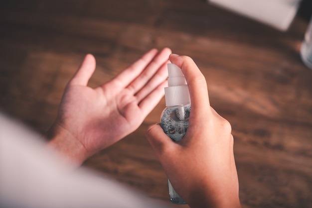 Uso di alcol spray per le mani per disinfettare, prevenire la diffusione di batteri e prevenire il virus corona (covid-19).