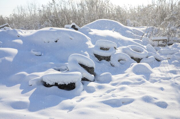 雪の厚い層で覆われた使用済みおよび廃棄されたタイヤ