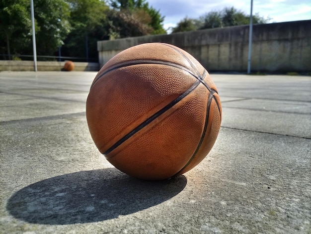 Used basketball ball on concrete surface of outdoor court