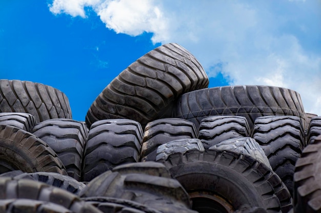 Used cartires reuse of the waste rubber tyres on blue sky background