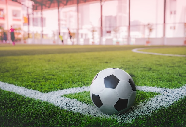 Used Classic black and white soccer ball on football field corner