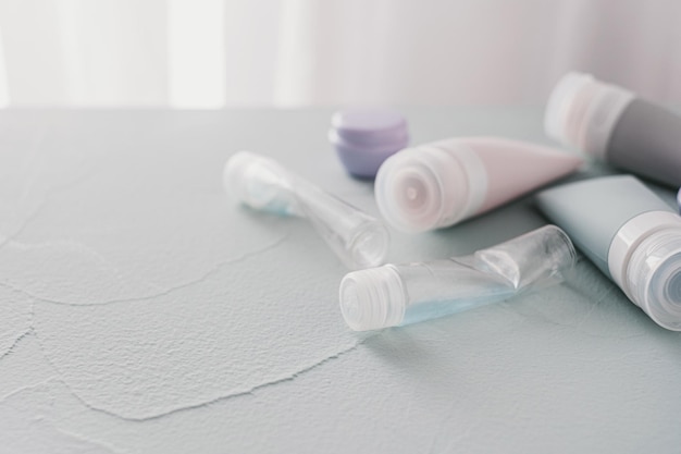 Used cosmetics tubes of cream and shampoo top view on a gray table