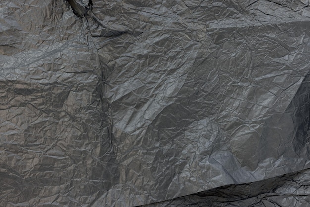 Used crumpled black wrapping paper texture background