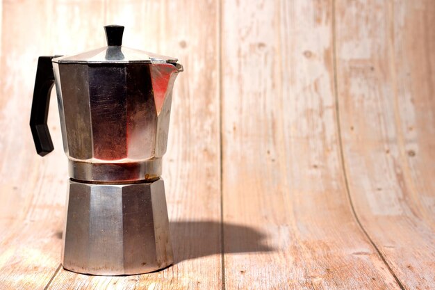 Used greca metal coffee pot on wood background