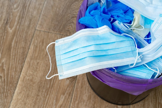 Maschere infettive usate e guanti medici nel cestino della spazzatura