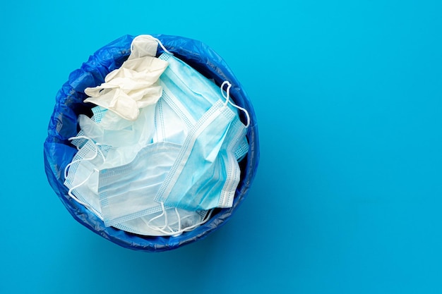 Used infectious masks and medical glove in the trash bin