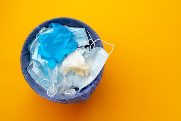 Used infectious masks and medical glove in the trash bin