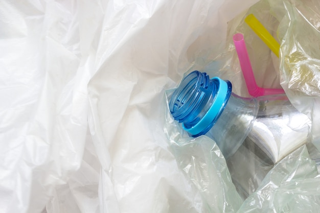 Used plastic bags, bottle and straws. 