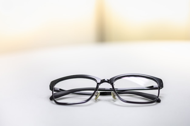 used reading glasses on white table.