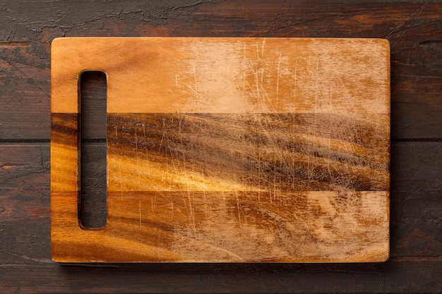 Used rectangular bamboo wooden cutting board on wooden table. Top view. Mock up for food project.