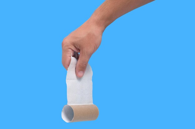 Used roll toilet paper in your hand on blue background.