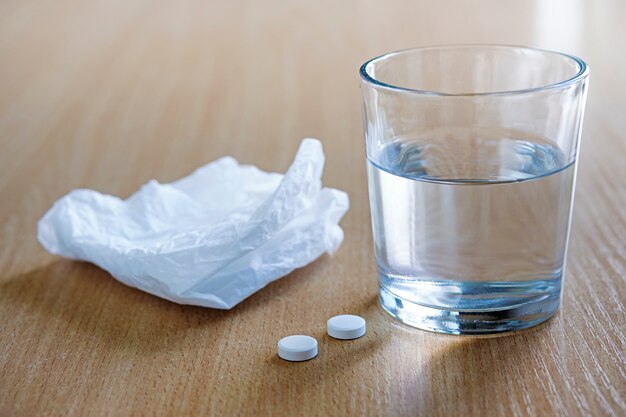 Used tissue with tablets and glass of water