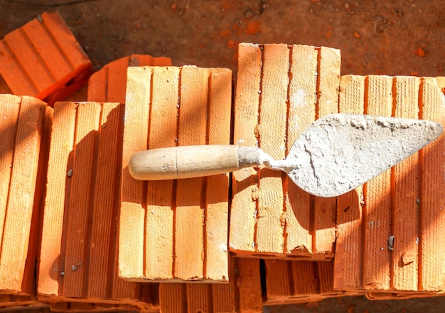 Used trowel put on brick pile at construction site