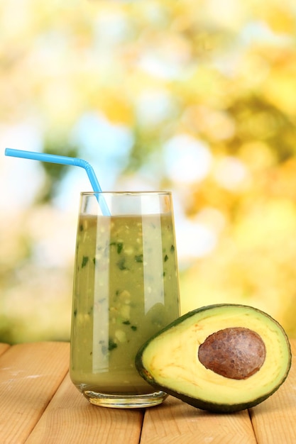 Useful fresh avocado and half avocado on wooden table on natural background