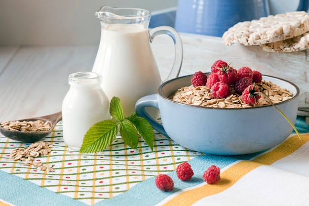 Useful homemade breakfast. Oatmeal, milk and fresh forest raspberries