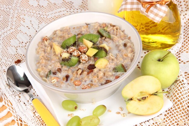 Useful oatmeal in bowl with fruit on wooden table closeup