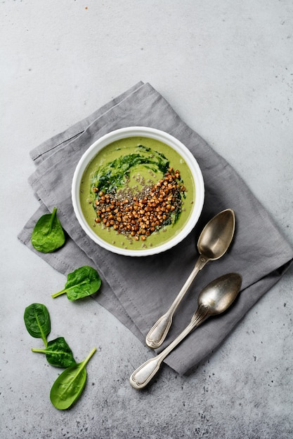Useful smoothies from spinach with buckwheat flakes in ceramic bowls