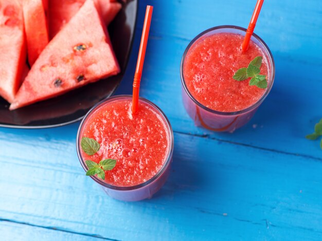 Useful summer refreshing watermelon smoothie in glasses on a blue background