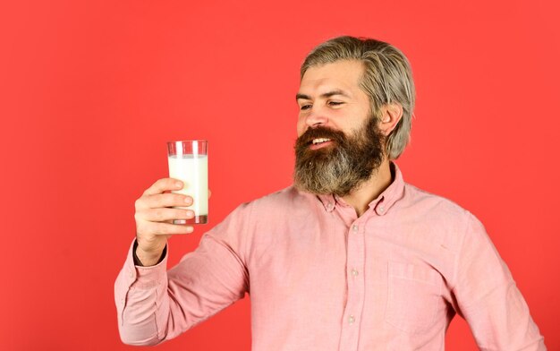 Usefulness of milk dairy products from milk for adults and children happy farmer present glass bearded man drink useful milk love milk mustache food and drink concept